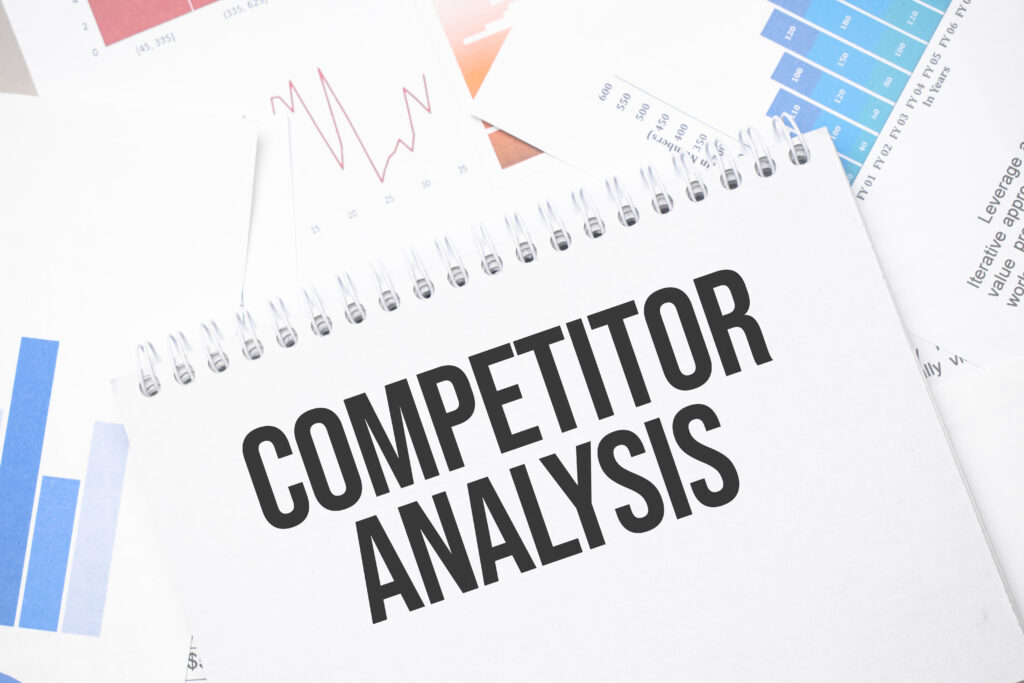 COMPETITOR ANALYSIS text on paper on the chart surface with pen