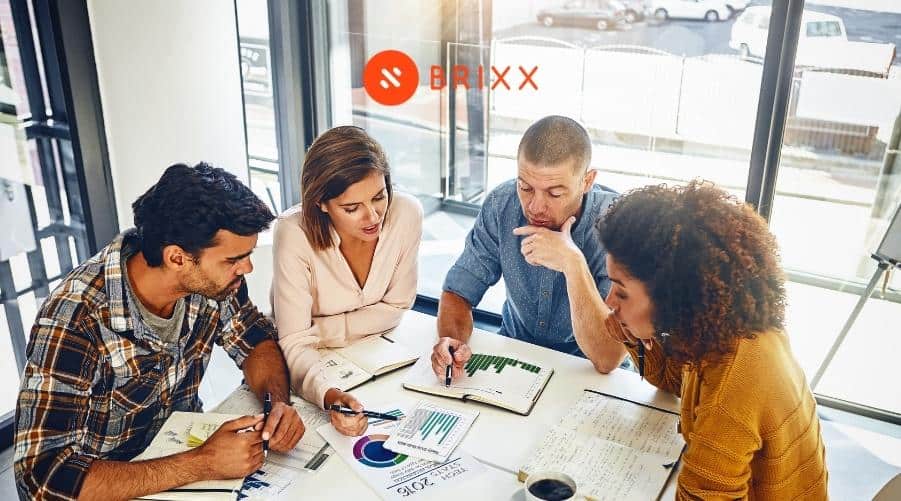 Image of a management team reviewing company figures for the How To Use The 3-Statement Financial Model To Grow Your Business blog post by Brixx