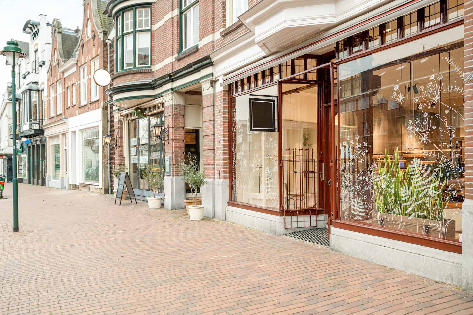 Brixx restaurant storefront with large glass windows and outdoor seating area.