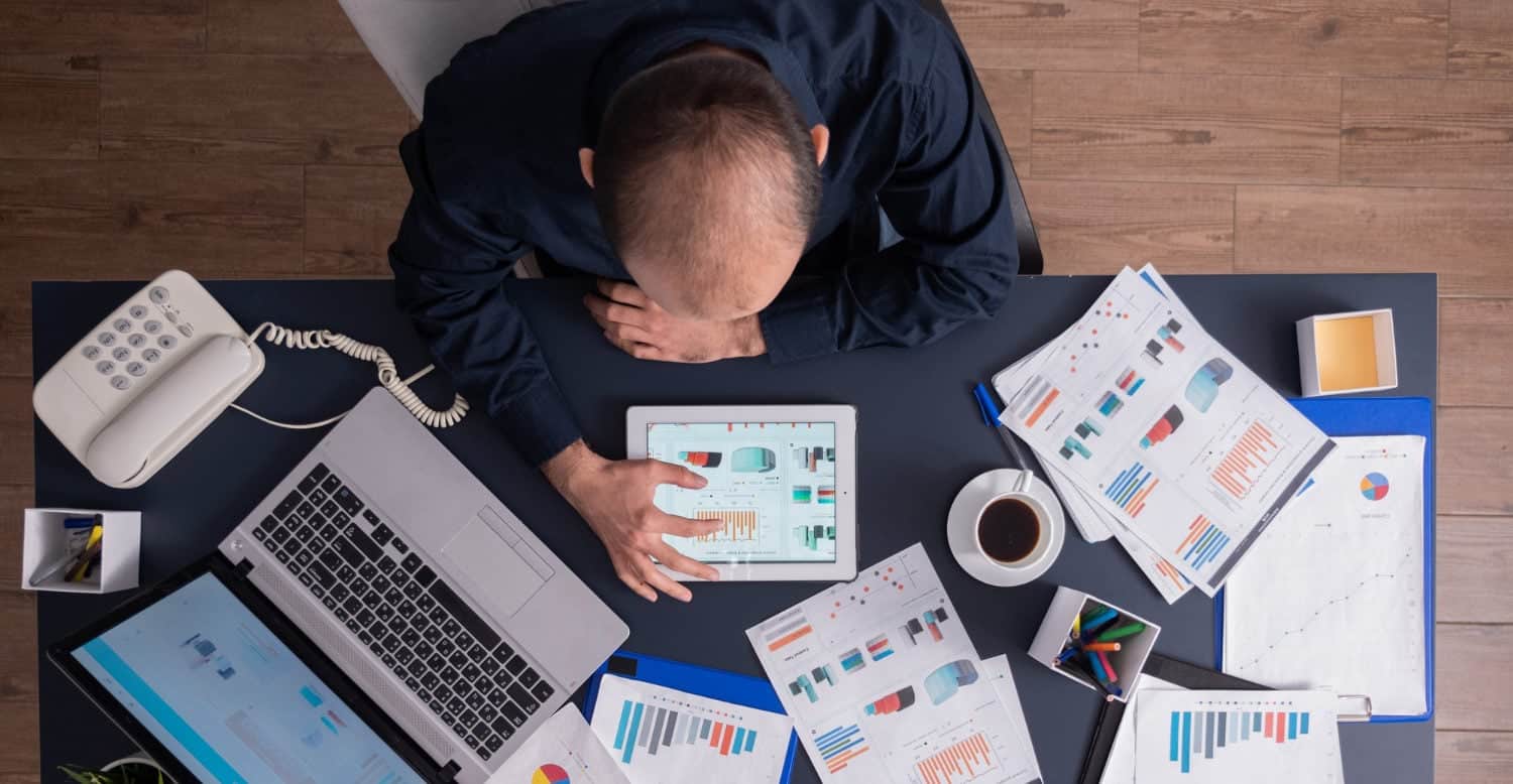 Business analyst analyzing data on tablet with charts and reports.